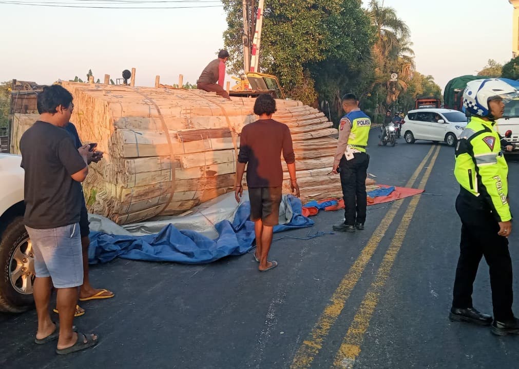 Melintas di Rel yang Miring, Truk Muat Kayu Terguling di Lamongan