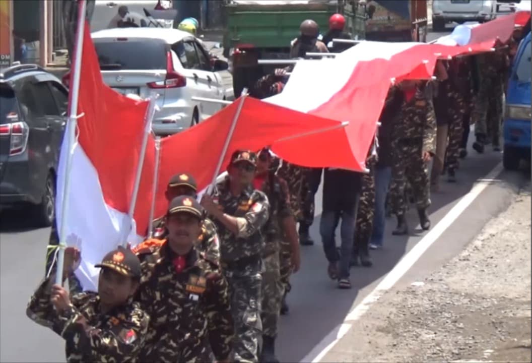 Semangat Patriotisme, Ratusan Banser Longmarch Bawa Bendera Merah Putih Raksasa di Jombang