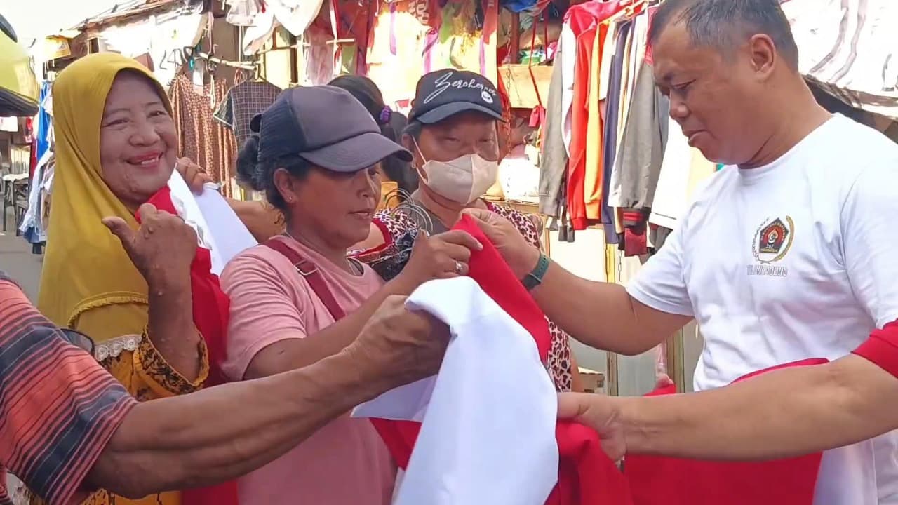 BAKESBANGPOL dan PWI Tulungagung Bagikan Ratusan Bendera ke Pedagang Pasar Wage