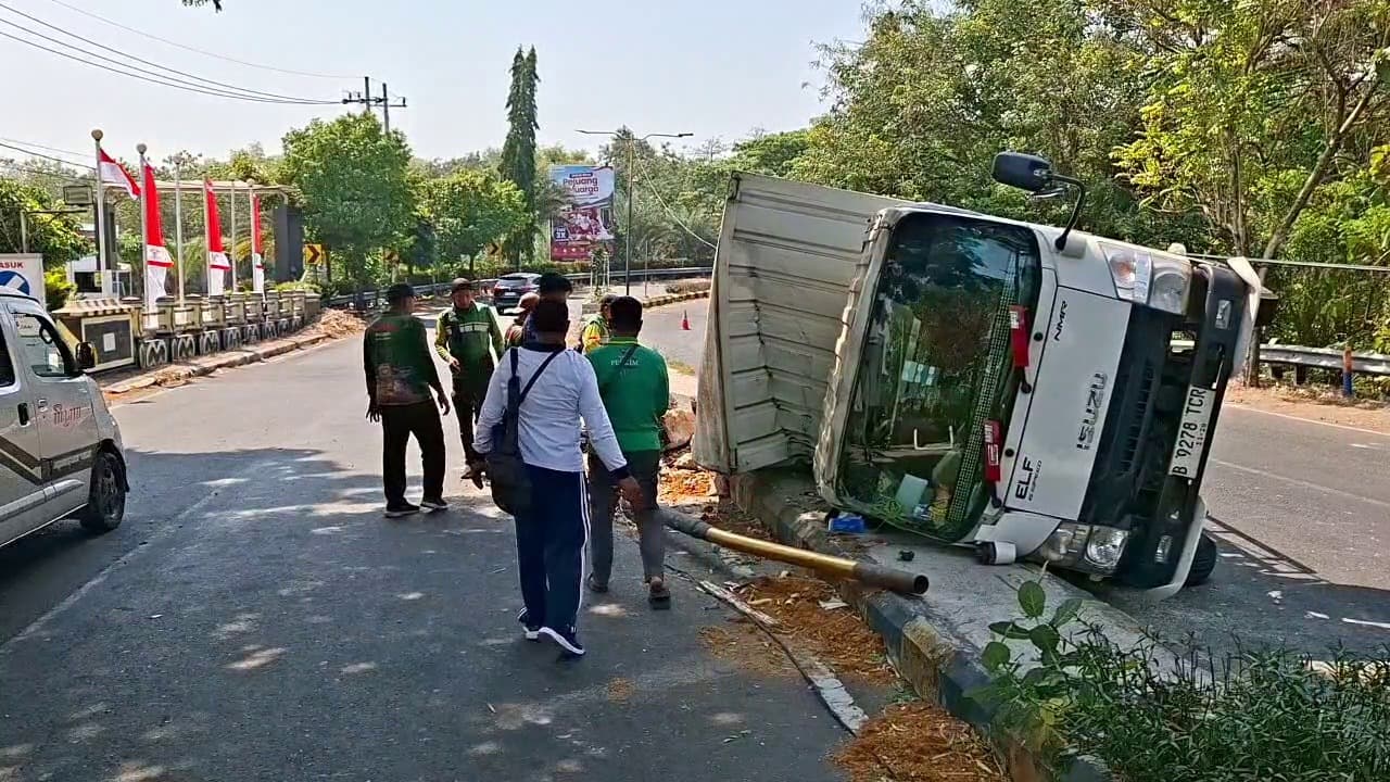Diduga Hilang Kendali, Truk Box Muatan Paket Terguling, Tabrak Median dan Tiang PJU